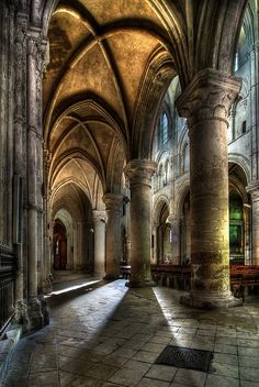 the interior of an old cathedral with stone floors and arches