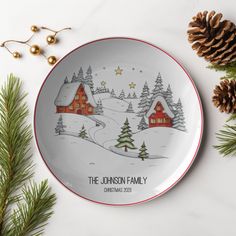 the personalized christmas plate is next to pine cones