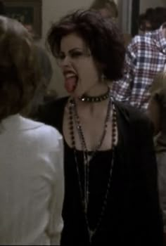 a woman with her mouth open and tongue out in front of other people at a party