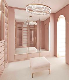 an empty room with pink walls and white flooring, a large mirror on the wall