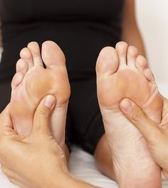 a woman laying in bed with her bare feet propped up on the bed and one foot raised