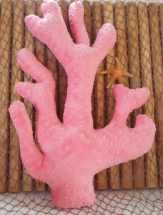 a pink coral shaped object sitting on top of a mat