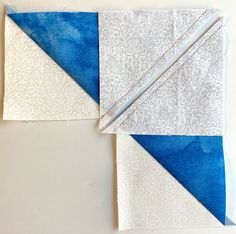 two pieces of blue and white fabric on top of each other, with one piece cut in half