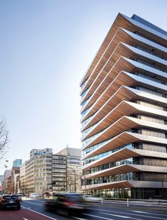 a very tall building sitting on the side of a road next to a street filled with traffic