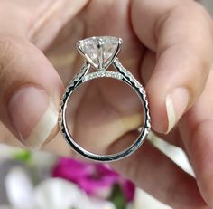 a close up of a person holding a diamond ring