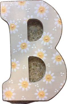 the letter b is decorated with daisies and yellow flowers on it's sides