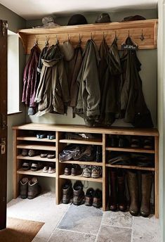 a coat rack with shoes and coats hanging on it