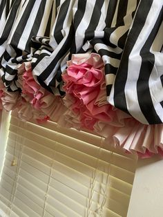 black and white striped curtains with pink ruffles hanging on the window sill