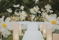 the aisle is decorated with daisies and candles