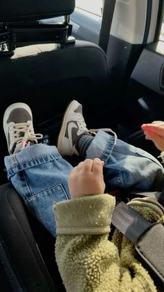 a child sitting in the back seat of a car