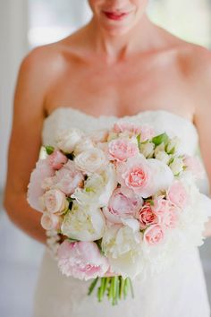 a bride holding a bouquet of pink and white flowers