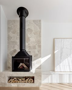 a fire place in the middle of a room with wood stacked on top of it