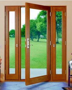 an open wooden door with glass panels in the middle of a living room and patio area