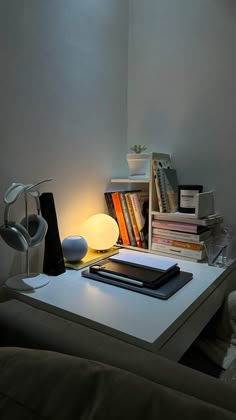 a white table topped with books next to a lamp