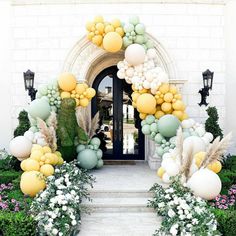 an archway decorated with balloons and flowers