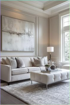 a living room filled with furniture and a large painting on the wall above it's windows