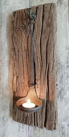 a light that is hanging on the side of a wooden wall with a candle in it