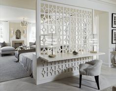 a living room filled with furniture and a white table topped with candles on top of it