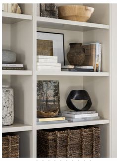 a book shelf filled with books and baskets