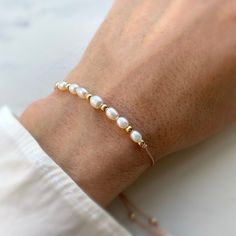 Elegant Hand-strung Friendship Bracelets With Round Beads, Elegant Friendship Bracelets With Round Beads, Adjustable Hand-strung Pearl White Pearl Bracelet, Adjustable Hand-strung White Pearl Bracelet, Elegant Rose Gold Bracelet With Sliding Knot, Adjustable White Pearl Bracelet In 14k Gold Filled, Elegant Adjustable 14k Gold-filled Beaded Bracelet, Elegant Gold Hand-strung Friendship Bracelets, Adjustable Pearl Bracelet With 14k Gold Filled Round Beads