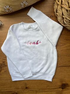 This cozy, soft-knit embroidered personalized sweater for children is designed for both comfort and style, perfect for keeping little ones warm while adding a touch of individuality. The sweater features a classic crewneck cut with ribbed cuffs and hem for a snug fit. The highlight is the custom embroidery across the chest, where a child's name or a fun word of your choice is beautifully stitched in vibrant, colorful thread. Ideal for gifting or special occasions, this sweater combines warmth and personalization in a delightful, kid-friendly way! Hand Embroidery Name Sweater, Custom Knit Sweater Kids, Hand Embroidered Name Sweater, Embroidered Sweaters Kids, Embroidered Baby Name Sweater, Personalized Sweater, Personalized Embroidered, Custom Embroidery, Kids Sweatshirt