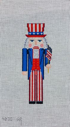 a cross stitch pattern with an image of a nutcracker in red, white and blue