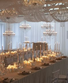 a long table is set with candles and place settings for an elegant dinner or reception