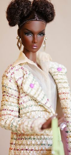 a barbie doll is holding a handbag