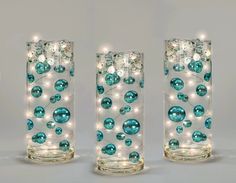 three glass vases with lights in them