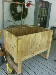 a wooden planter sitting on top of a porch next to a yellow tool box