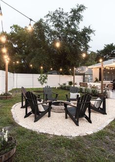 an outdoor patio with chairs and lights strung in the back yard, surrounded by grass