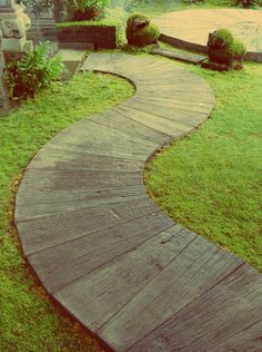 a wooden walkway in the middle of a grassy area