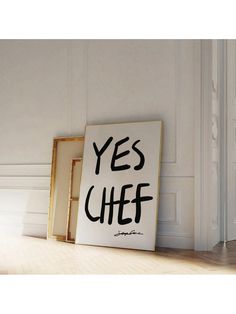 there is a sign that says yes chef on the floor next to an empty frame