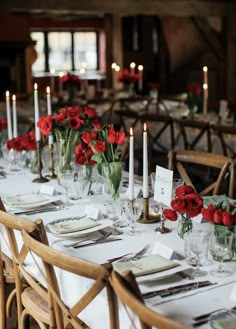 a long table is set with red roses and candles