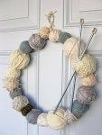 a yarn ball wreath hanging on the front door