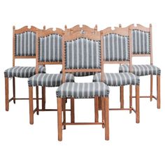 six wooden chairs with striped upholstered back and seat cushions, all lined up against each other