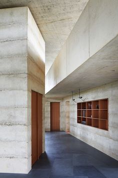 an empty room with concrete walls and wooden doors