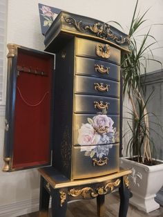 an ornate chest of drawers with flowers painted on the side and gold trimmings