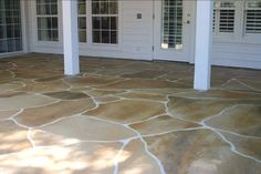 an outdoor patio with stone flooring and white doors