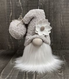 a stuffed animal with white fur and a flower on it's head