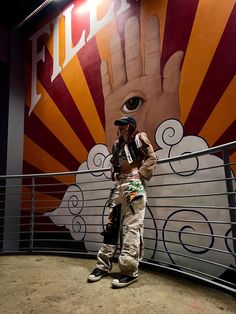 a man standing in front of a large mural