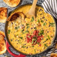 a red skillet filled with cheese and black beans next to bread on a table