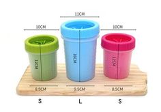 three different colored cups sitting on top of a wooden tray with measurements for each cup