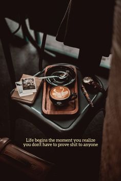 a cup of coffee sitting on top of a wooden tray next to a book and magazine