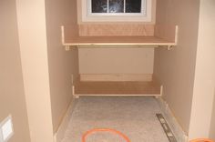 an empty closet with shelves and a toy hula hoop on the floor next to it