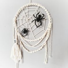 a white and black spider dream catcher hanging on a wall