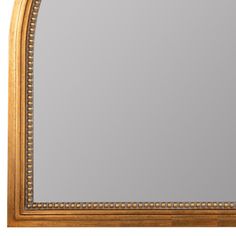 an ornate gold framed mirror with beaded trimmings on the edges and sides