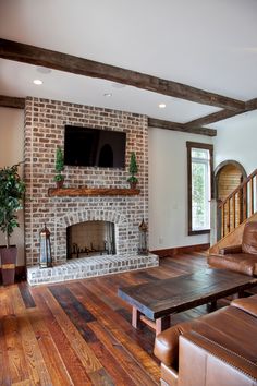 a living room filled with furniture and a flat screen tv mounted above a fire place