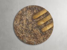 a marble plate with gold colored food items on the top and bottom, in front of a gray wall