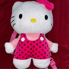 a hello kitty stuffed animal with pink and black polka dots on it's chest